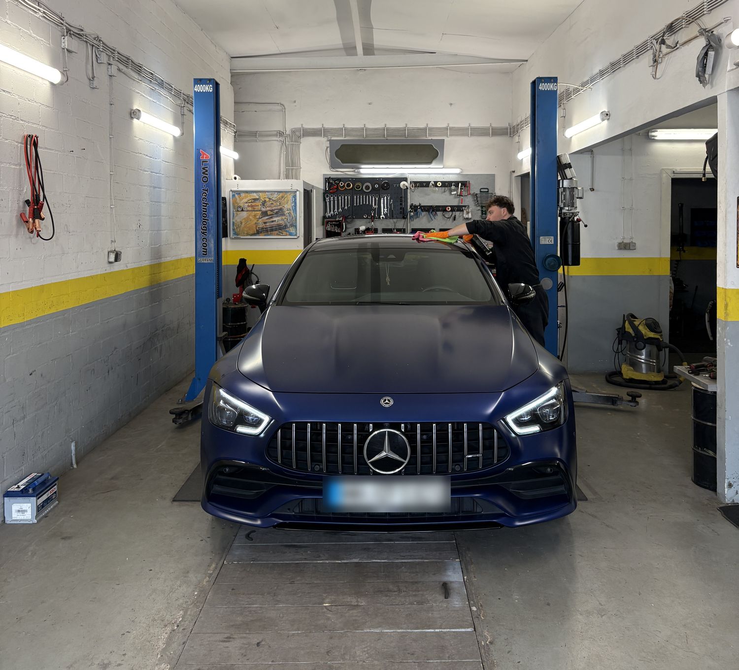 Unser Team bei der Aufbereitung eines Mercedes-AMG in der Werkstatt, daneben die Hebebühne